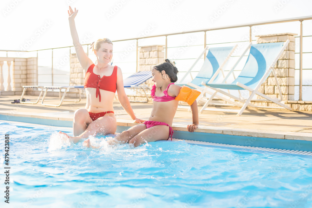 Happy mother and daughter in the swimming pool at the leisure center