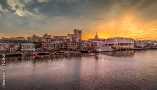 Sunset view of Savannah Georgia with the Savannah river and the docks and famous riverside buildings stunning orange sky