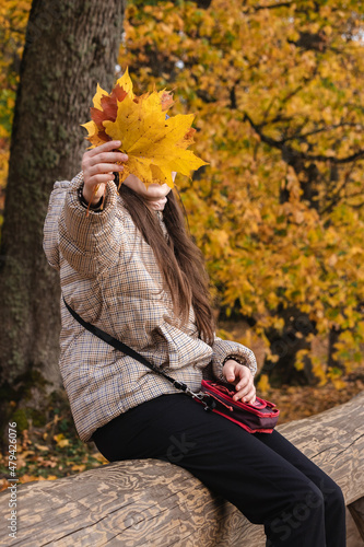 young girl with yellow autumn leaves photo