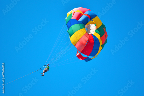 A person is flying in parachute of a lot colors. Parachute in the sky.