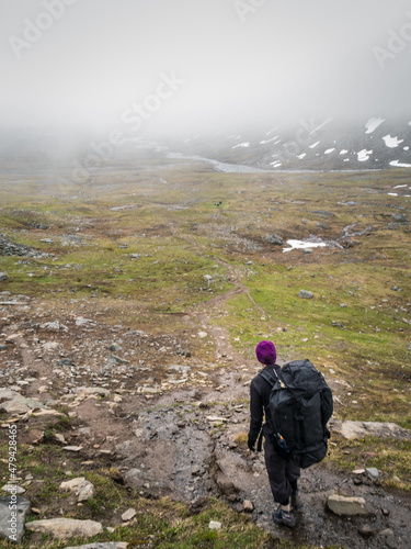 hiker with backpack in the mountains with fog photo