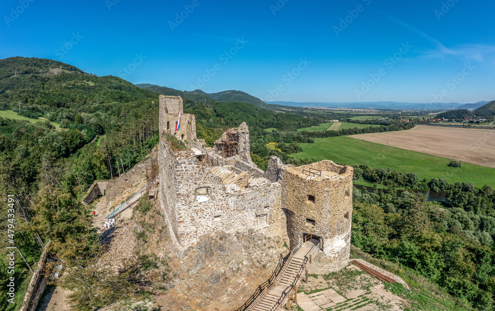 Aerial view of Reviste castle above the Hron river with partially restored gate tower, palace walls and donjon