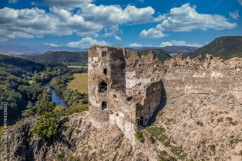 Aerial view of the entrance to Sasovsky castle above the Hron river in Slovakia with double defensive structure protecting the gate cloudy blue sky