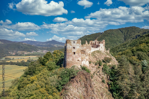 Aerial view of Sasovsky Hrad or Castle in central Slovakia above the Hron river with circular gate tower and adjacent palace building on a steep mountain top