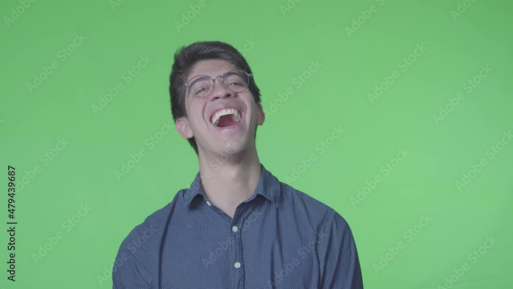 hombre latino riendose muy fuerte con fondo verde