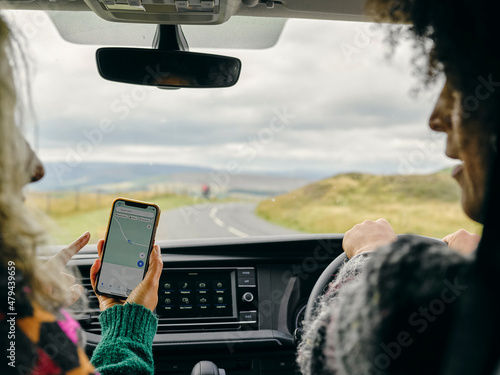 Women using GPS on smart phone in car photo