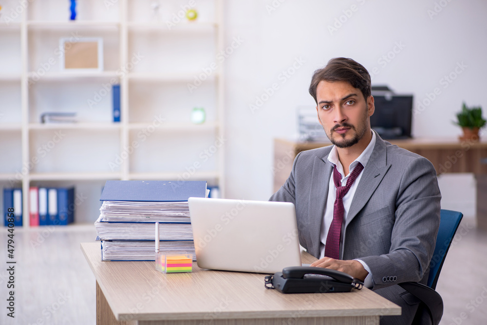 Young male employee working in the office Young male employee working in the office