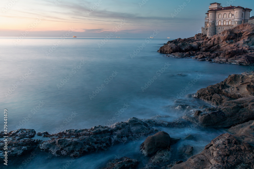 Boccale castle landmark on cliff rock and sea on warm sunset.
