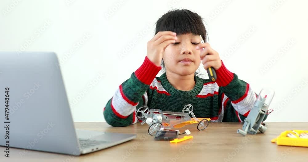 The little girl asian building robotic car in science lesson in the house . Which increases the development and enhances learning skills gifted brilliant children working with technology. The little girl asian building robotic car in science lesson in the house . Which increases the development and enhances learning skills gifted brilliant children working with technology.