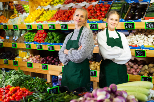 Young girl helping her mother work as a salesman in a grocery store