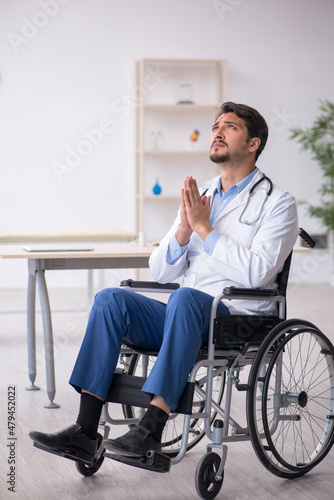 Young male doctor in wheel-chair working in the clinic © Elnur