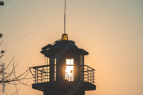 Silhoutette light house with tropical sunset. photo