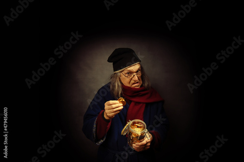 Scrooge wearing a cap and a scarf, putting gold coins in a jar Fototapet