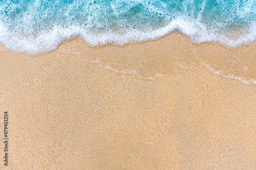 Soft beautiful blue ocean wave on sandy beach. Background. top view