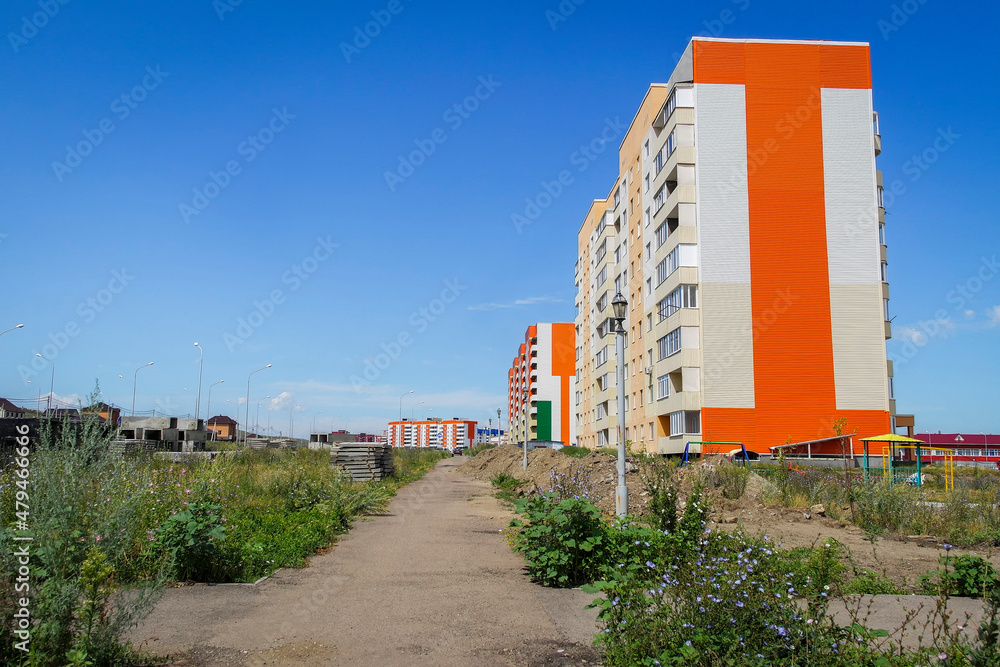 Obraz premium Modern apartment buildings. kazakhstan (Ust-Kamenogorsk). New residential area. Contemporary architecture. Blue Sky and Green Grass. New Houses