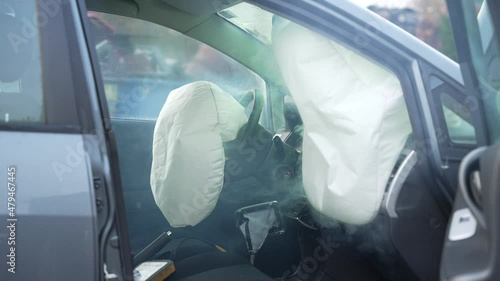 Three airbags exploding in a still standing car in slowmotion photo