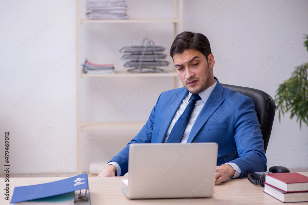 Young male employee being unhappy with excessive work Young male employee being unhappy with excessive work