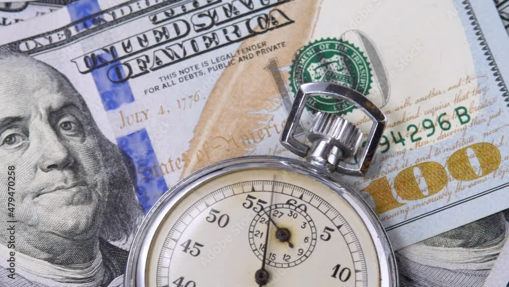 100 USD denomination note with metal stopwatch. Time is money. Currency or cash revenue, business or financial concept 100 USD denomination note with metal stopwatch. Time is money. Currency or cash revenue, business or financial concept