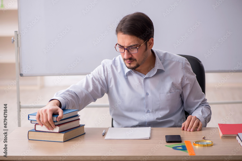 Young male teacher in front of whiteboard Young male teacher in front of whiteboard