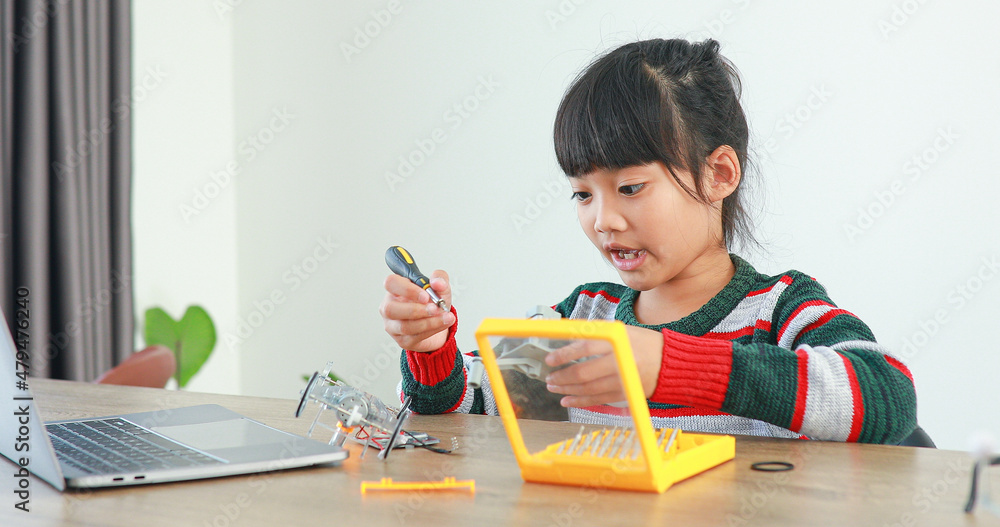 The little girl asian building robotic car in science lesson in the house . Which increases the development and enhances learning skills gifted brilliant children working with technology. The little girl asian building robotic car in science lesson in the house . Which increases the development and enhances learning skills gifted brilliant children working with technology.