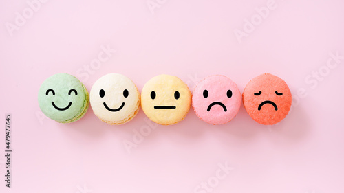 emotion face on multi colored macarons , good feedback rating and positive customer review, experience, satisfaction survey ,mental health assessment, child wellness, world mental health concept photo