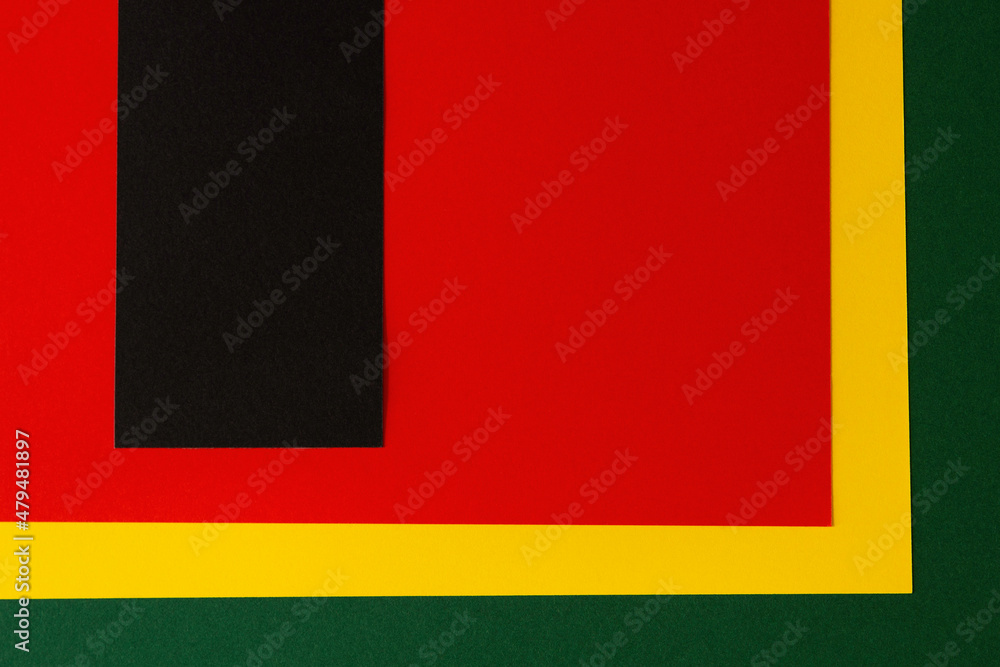Fototapeta premium Abstract geometric background. Black vertical stripe with copy space on red, yellow, green color background. Black History Month background