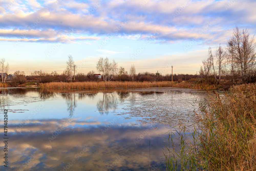 Clouds in the sky with reflection in the lake at sunset.