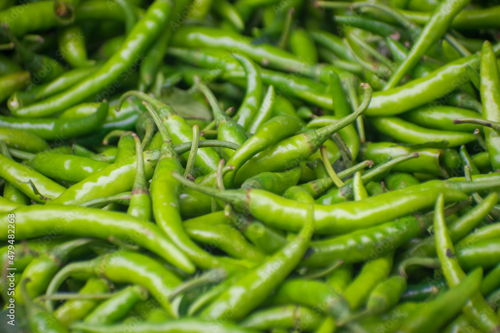 Heap of green Cayenne pepper. Capsicum annuum. It is usually a moderately hot chili pepper used to flavor dishes. Heap of green Cayenne pepper. Capsicum annuum. It is usually a moderately hot chili pepper used to flavor dishes.