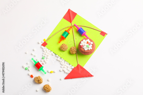 Indian festival makar sankranti concept, Colorful kite ,string and sweet sesame seed ball. © PRASANNAPIX