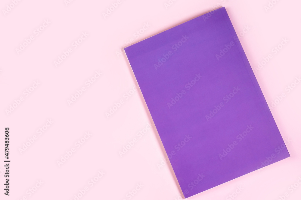 Notebook in the color Very peri trend 2022 lies on a pink table. Notebook in the color Very peri trend 2022 lies on a pink table.