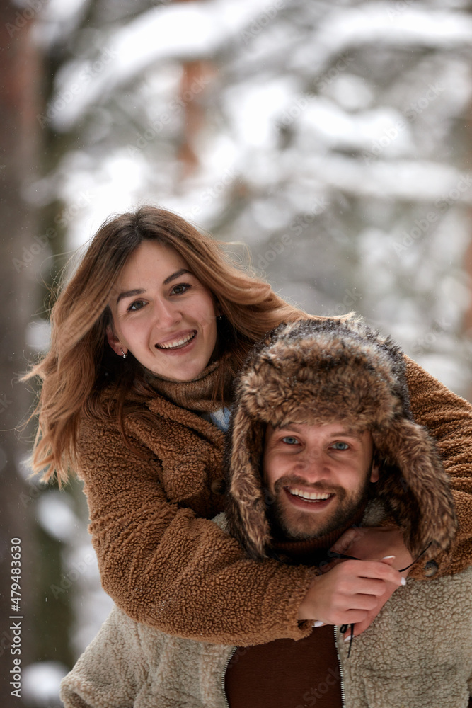 People, season, love and leisure concept - happy couple hugging and laughing outdoors in winter. Couple embracing and having fun in snowy winter park People, season, love and leisure concept - happy couple hugging and laughing outdoors in winter. Couple embracing and having fun in snowy winter park