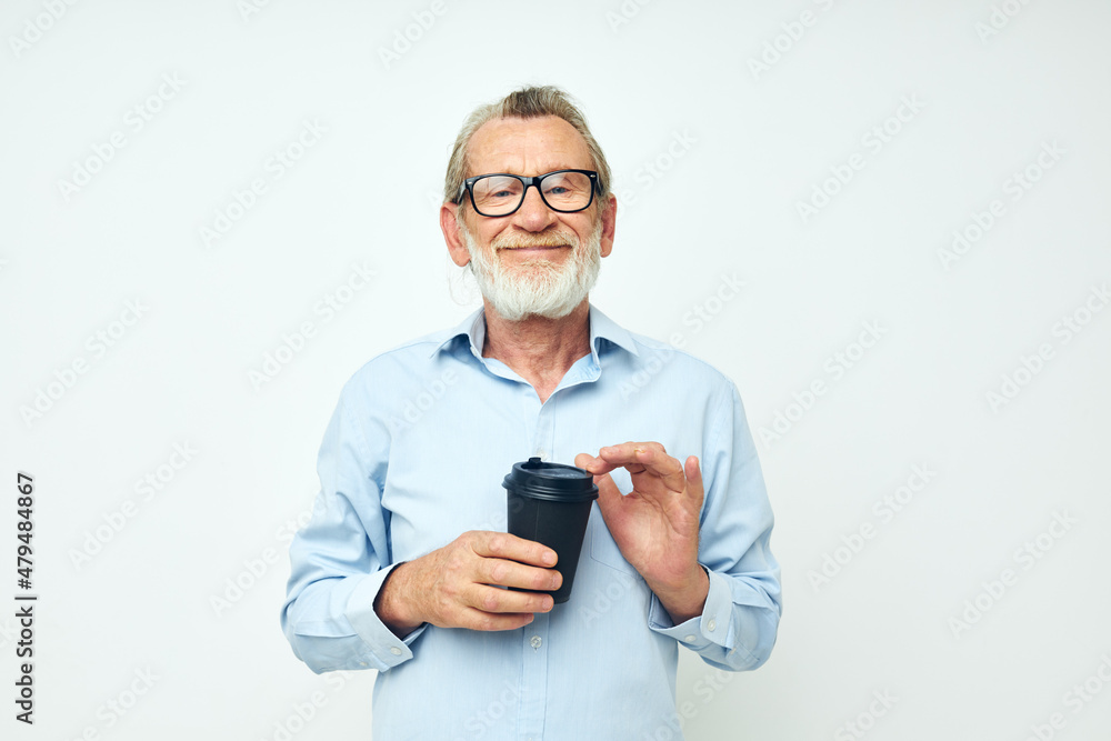 Photo of retired old man gestures with his hands a glass of drink light background Photo of retired old man gestures with his hands a glass of drink light background