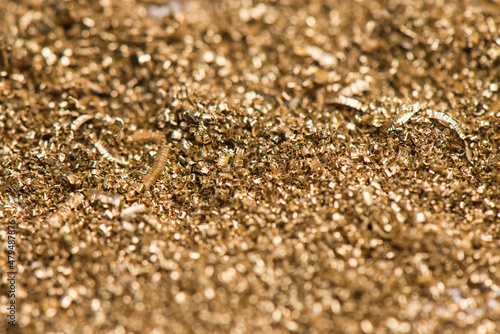 Small shavings of brass after lathe work. Industrial waste from the metallurgical industry. Selective focus. photo