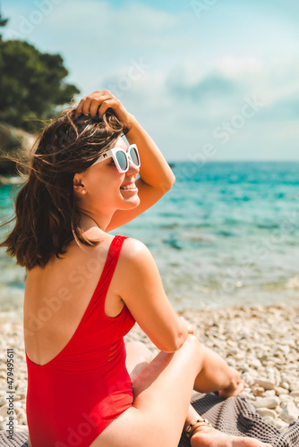 woman sitting on blanket at sea beach