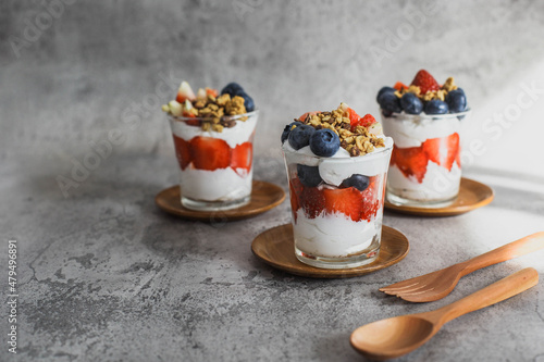 Japanese popular dessert parfait made with fresh fruit, yogurt and granola isolated on cement background