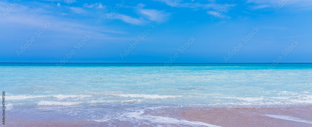 Fototapeta premium Panorama of a deserted beach. Turquoise clear water and blue sky in sunny weather on the beach in Melbourne, Florida