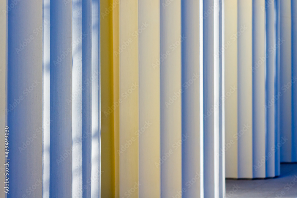 Columns of a historic building are light yellow, shot on a bright sunny day against a blue sky. Columns of a historic building are light yellow, shot on a bright sunny day against a blue sky.