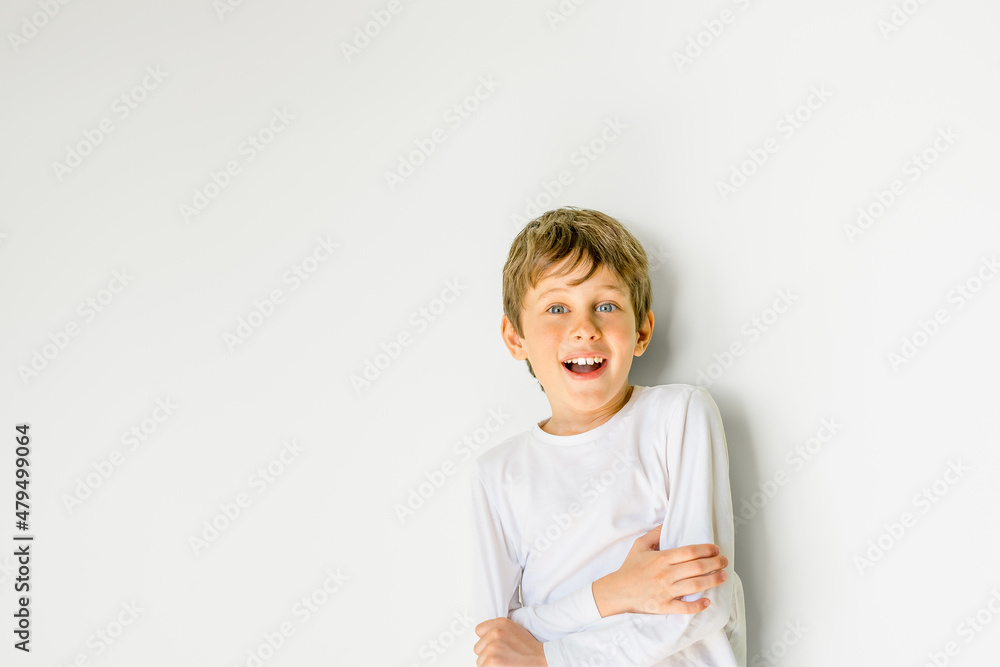 A second grader of an elementary school looks into the camera with enthusiasm and surprise. Portrait of a white eight year old boy with copy space. Bright children's emotions A second grader of an elementary school looks into the camera with enthusiasm and surprise. Portrait of a white eight year old boy with copy space. Bright children's emotions