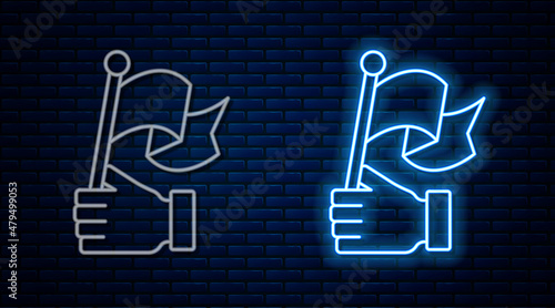 Glowing neon line Hand holding flag icon isolated on brick wall background. Victory, winning and conquer adversity concept. Vector