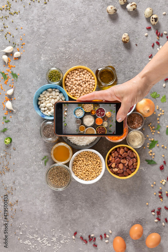 A woman photographs the ingredients of the diet on a smartphone.