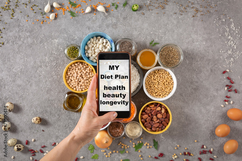 woman takes pictures on a smartphone and has a slogan on the screen My diet plan is health, beauty and longevity, top view