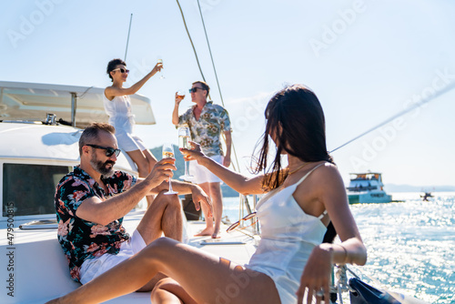 Fotobehang Group of Caucasian people friends enjoy luxury party drinking champagne together while catamaran boat sailing in the ocean