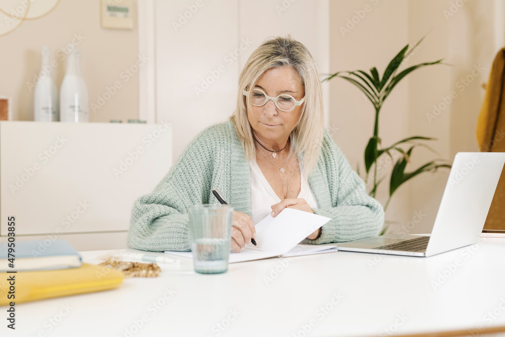 Businesswoman planning on book in office Businesswoman planning on book in office