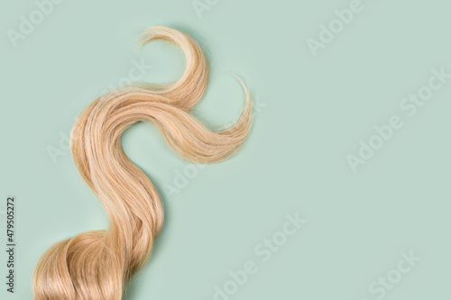 Fényképezés Curly blonde hair on mint background