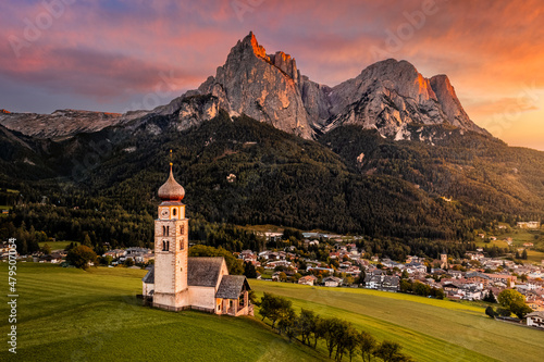 Obraz na płótnie Seis am Schlern, Italy - Beautiful sunset and aerial mountain scenery in the Italian Dolomites with St. Valentin Church and famous Mount Sciliar with colorful clouds and warm sunlight at South Tyrol w salonie