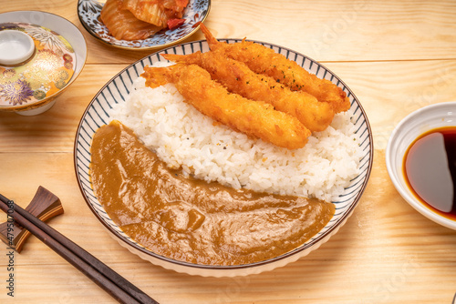 Japanese food curry rice with fried shrimp tempura on wooden table, Traditional Japanese food.