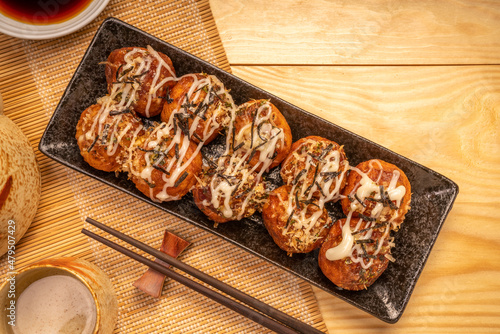 фотографія Japanese food Takoyaki octopus balls with takoyaki sauce on wooden table, Traditional Japanese food