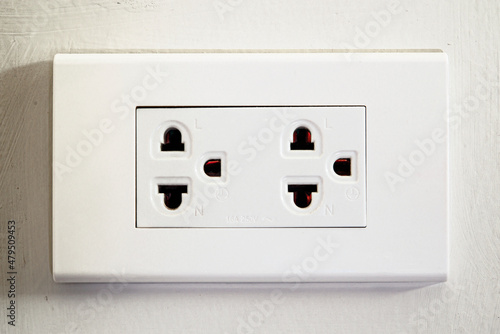 Wall-mounted power plug used for sockets with 3 prongs.