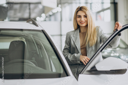 Attractive woman in car showroom buying a car