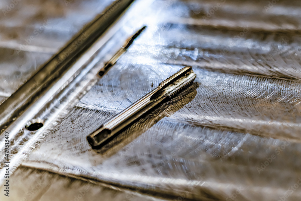 Tapping a hole with an oil-lubricated hand tap in a locksmith's shop. Tapping a hole with an oil-lubricated hand tap in a locksmith's shop.